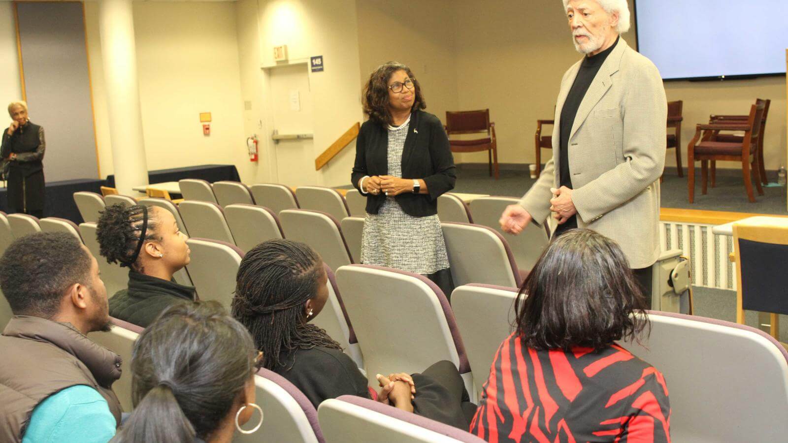Image of Ron Dellums and Dean Crewe standing in front of students