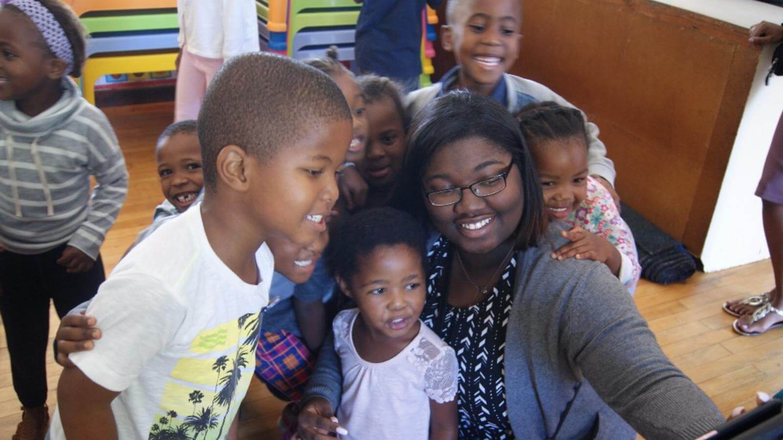 Image of social work student with children taking a picture