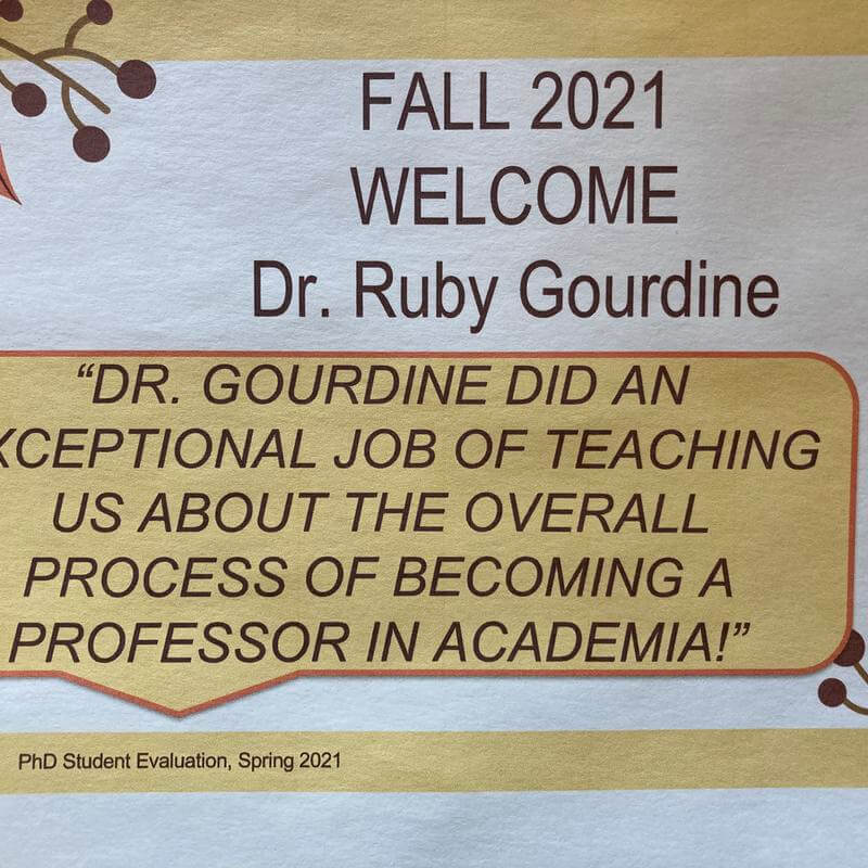 A poster featuring a quote about Dr. Gourdine, reading "Dr. gourdine did an exceptional job of teaching us about the overall process of becoming a professor in academia!"